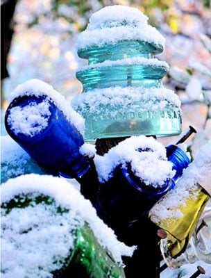 blue bottles and insulators covered in snow
