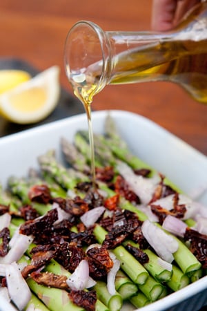 Drizzling asparagus with olive oil