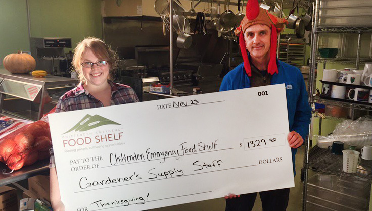 Employee handing giant check to food shelf employee for turkeys