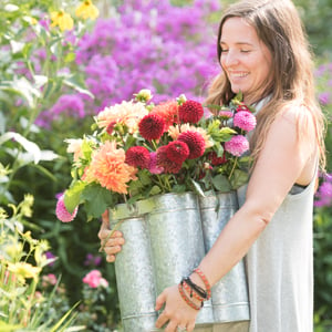  Woman holding galvanized container of dahlias
