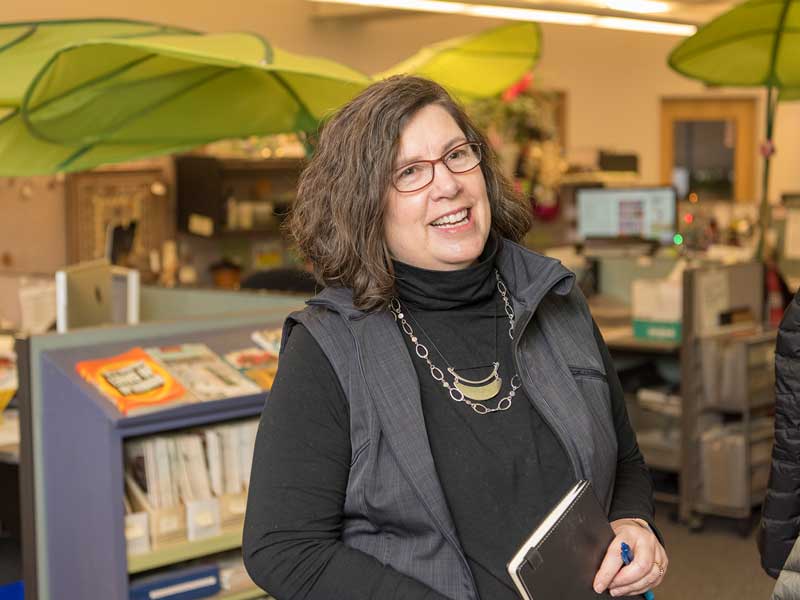 Employee smiling holding notebook