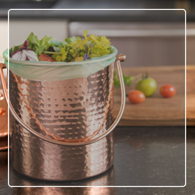 Hammered Copper Kitchen Compost Pail filled with food scraps on kitchen counter
